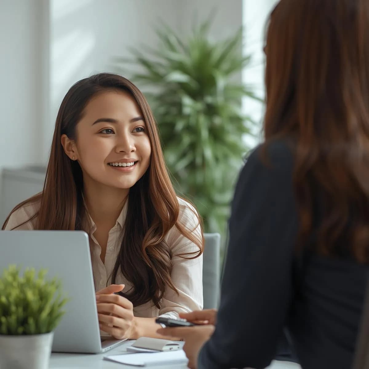 Practitioner talking with a client across a desk during a consultation