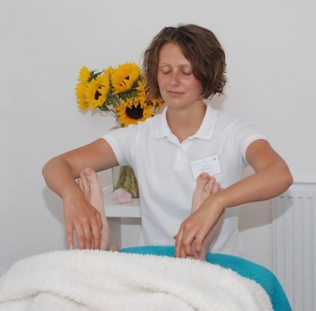 Reflexologist applying pressure to a client's foot