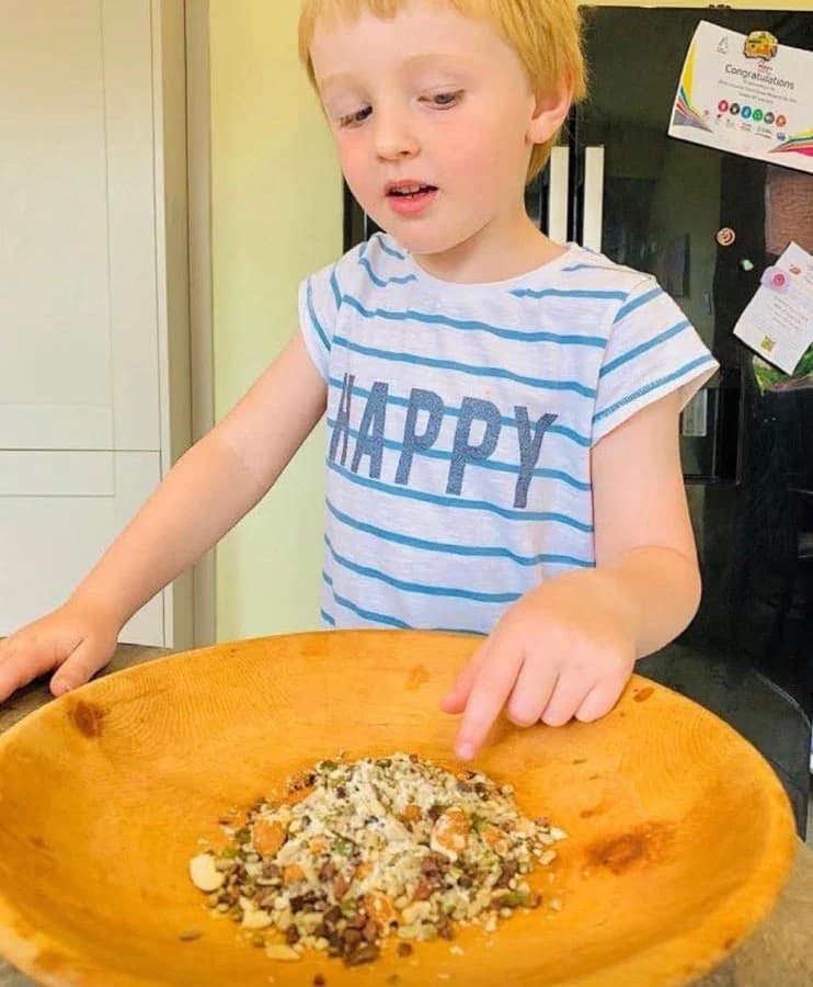 Young child eating a bowl of fresh fruit